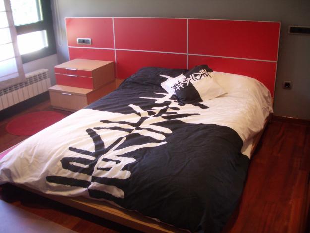 Dormitorio juvenil con cama japonesa, mesa de trabajo y estanterias.